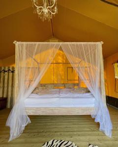 a bed with a mosquito net in a room at Great-Lake-Lodge-Spektakulaerer-Glampingurlaub-am-Grossensee in Großensee
