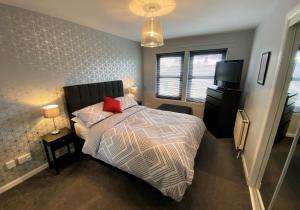 a bedroom with a bed and a television in it at NEW Super 2 Bedroom Flat in Falkirk in Falkirk