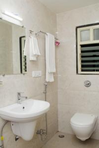 een badkamer met een wastafel, een toilet en een spiegel bij HOTEL NEW BHARTI in Aurangabad