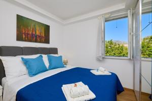 - une chambre avec un lit bleu et blanc et une fenêtre dans l'établissement Villa Larum, à Mokošica