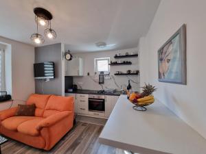 a living room with an orange couch and a kitchen at Lavanda in Livno