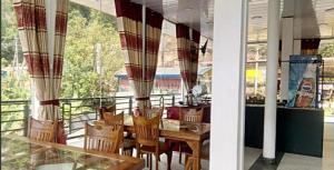 a dining room with a table and chairs on a balcony at Ramboda holiday Inn in Kotmale
