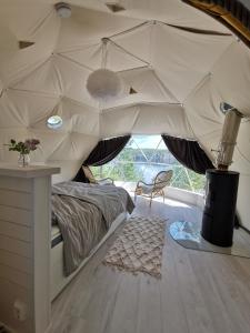 1 dormitorio con 1 cama en una tienda de campaña en Hidden Island Laukanharju Glamping, en Savonlinna