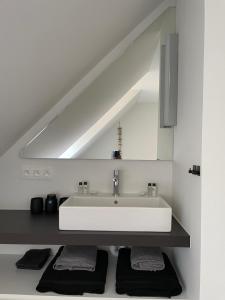 a white bathroom with a sink in a room at Residentie Square - Nieuwbouw - 50 m van de zee in Knokke-Heist