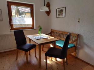 een eetkamer met een tafel en stoelen en een raam bij Ferienwohnung Ritzinger in Perlesreut