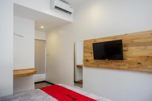 una camera da letto con TV a schermo piatto a parete di RedDoorz @ Klaten City a Klaten