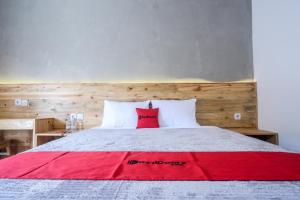 a bedroom with a large bed with red and white pillows at RedDoorz @ Klaten City in Klaten