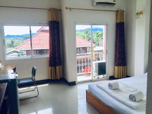 a bedroom with a bed and a large window at Hom pho guesthouse in Ban Houayxay