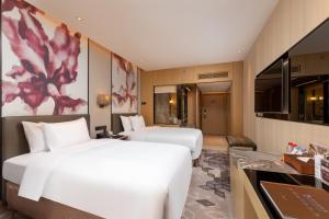 Postel nebo postele na pokoji v ubytování Zhuhai Longzhuda International Hotel