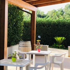 a patio with two tables and chairs under a pergola at Casa Giulia in Niscemi