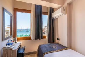 a hotel room with a bed and a window at Akkan Hotel in Bodrum City