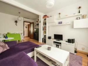 sala de estar con sofá púrpura y mesa en La Adicidad de Castellón, en Móstoles