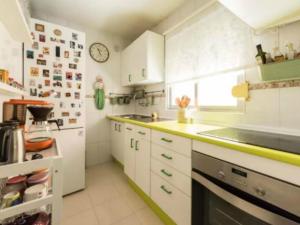 uma cozinha com armários brancos e uma bancada em La Adicidad de Castellón em Móstoles