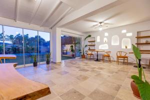 a living room with a table and chairs and windows at Alacati Fora Bella in Alacati