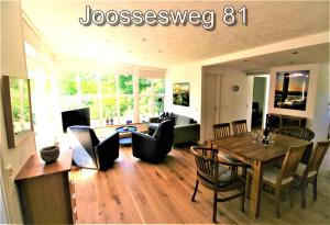 een woonkamer met een tafel en stoelen en een bank bij Joossesweg 81 in Westkapelle