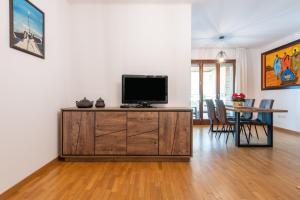 a living room with a television on a wooden cabinet at Casa Paola in Cagliari