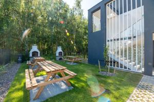 un jardín con 2 mesas de picnic y un edificio en Apartamenty Sun Seasons 24 - Zaciszna, en Niechorze
