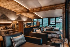 ein Wohnzimmer mit Ledersesseln und einer Couch in der Unterkunft DolceVita Hotel Jagdhof in Latsch