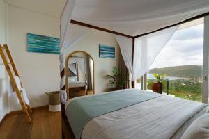 een slaapkamer met een bed en een groot raam bij Villa Santosa Heights in Kuta Lombok +31 foto's