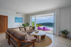 een woonkamer met een bank en een tafel bij Villa Santosa Heights in Kuta Lombok