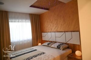 1 dormitorio con 1 cama con cabecero y ventana en Apartman Mosaic, en Doboj