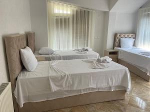 Habitación de hotel con 2 camas con sábanas blancas en Hotel Montenegro, en Struga