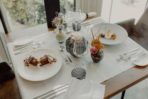 Biały stół z talerzami żywności w obiekcie DolceVita Hotel Jagdhof w mieście Laces