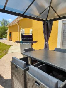 a picnic table and chairs under a black umbrella at Villa suzana in La Suze-sur-Sarthe