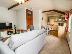 a living room with a couch and a kitchen at Ash Cottage in Ilfracombe