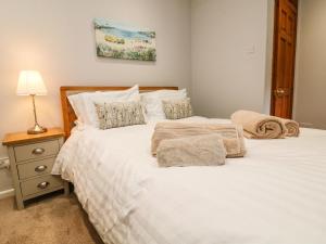 a bedroom with two beds and a lamp on a night stand at Ash Cottage in Ilfracombe