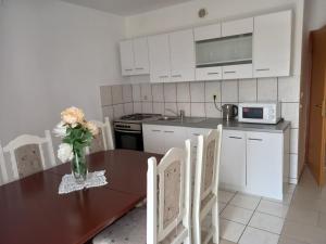 una cocina con una mesa con un jarrón de flores. en Apartments Vrdoljak, en Pag