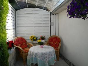 a patio with two chairs and a table with flowers on it at Bungalow Rarek "20 Gehmin vom Ostseestrand" in Gothen