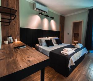 Schlafzimmer mit einem Bett und einem Holztisch in der Unterkunft TEPE HOTEL&BUSINESS SUITE in Antalya