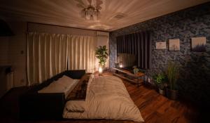 uma sala de estar com uma cama e um sofá em HAKUDAKU no YUYA em Beppu