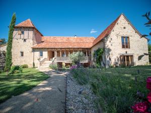 a large stone house with a yard with flowers at VILLA MARCAUSI in Lissac et Mouret