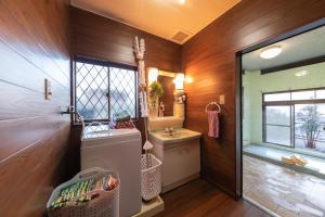 een badkamer met een wastafel en een spiegel bij 別府温泉 小倉の湯 in Beppu +10 foto's