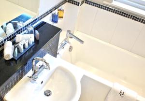 a bathroom with a sink and a bath tub at Holbeck Ghyll Country House Hotel with Stunning Lake Views in Windermere