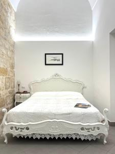 una camera con un letto bianco e un copriletto bianco di Casa Tancredi a Scicli