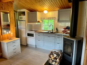 a kitchen with white cabinets and a stove at Fjällhalsen Cottages in Fjällhalsen