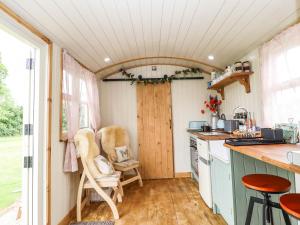 a kitchen with a counter and chairs in a tiny house at Honeybee Lodge in Woodhall Spa