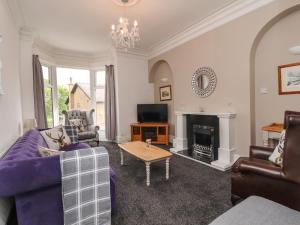a living room with purple furniture and a fireplace at The Old Post Office in Burnley