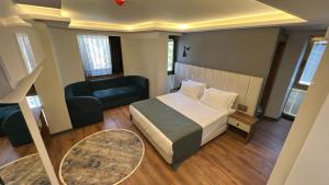 Nira Boutique Hotel في أنقرة: غرفة نوم بسرير واريكة وطاولة