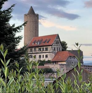 um edifício antigo com uma torre alta ao fundo em Klassisches Apartment in historischer Burg in Schlitz em Schlitz
