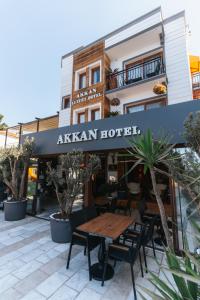 a restaurant with a wooden table in front of a building at Akkan Hotel in Bodrum City
