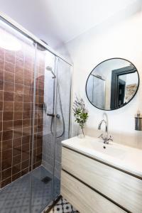 a bathroom with a sink and a shower with a mirror at Apartamentos El Patio, Plaza Mayor Trujillo in Trujillo