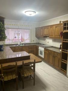a kitchen with wooden cabinets and a wooden table at Apartamento Couto in Ribadeo