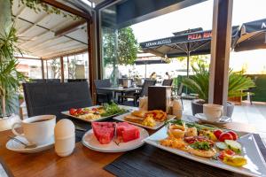 a table topped with plates of food and cups of coffee at Akkan Hotel in Bodrum City