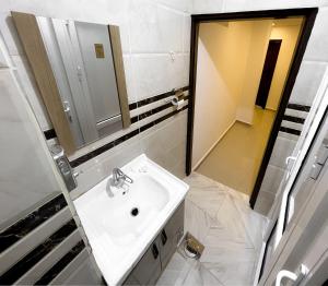 a white bathroom with a sink and a mirror at Petra Cloud 1977 in Wadi Musa +12 photos
