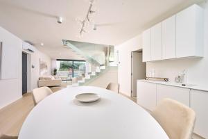 eine Küche und ein Esszimmer mit einem weißen Tisch und Stühlen in der Unterkunft Villa Pura Vida in Materada