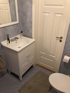 a white bathroom with a sink and a mirror at Stor Familjegård i bra läge in Finström +24 photos